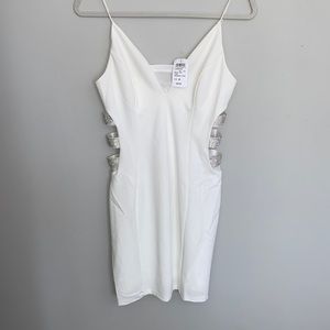 Ivory formal dress, curve complementing side cuts with rhinestones.